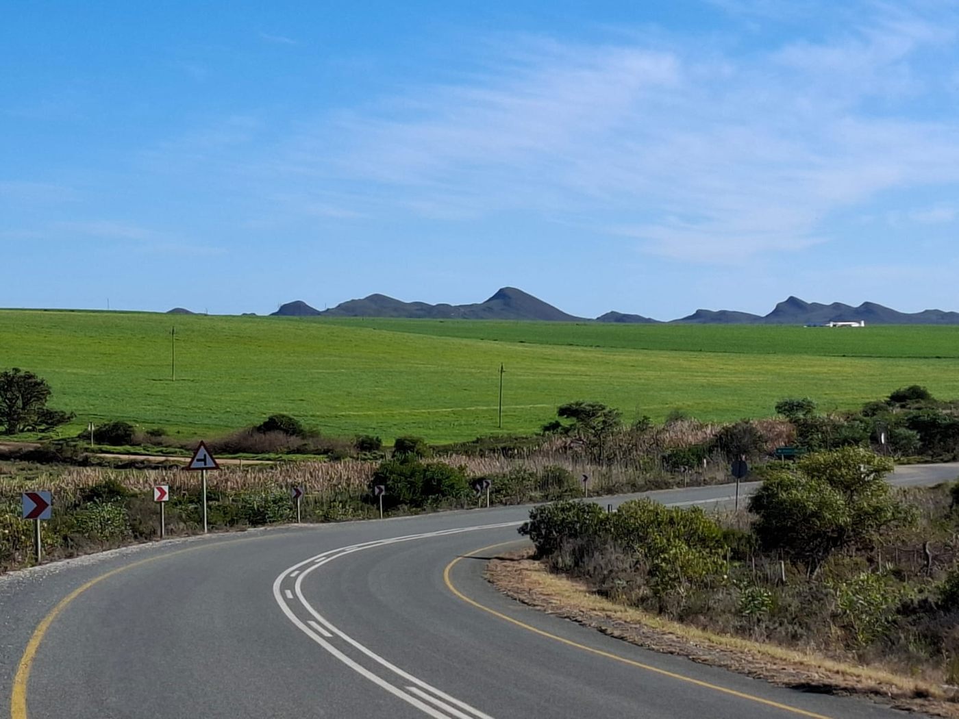 Die Asphaltstraße, die sich durch das umliegende Farmland des Overberg windet