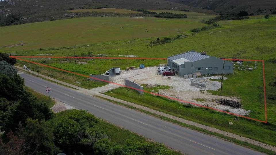 The property outlined in red from the air, the house at its far corner and the Main Road along its front