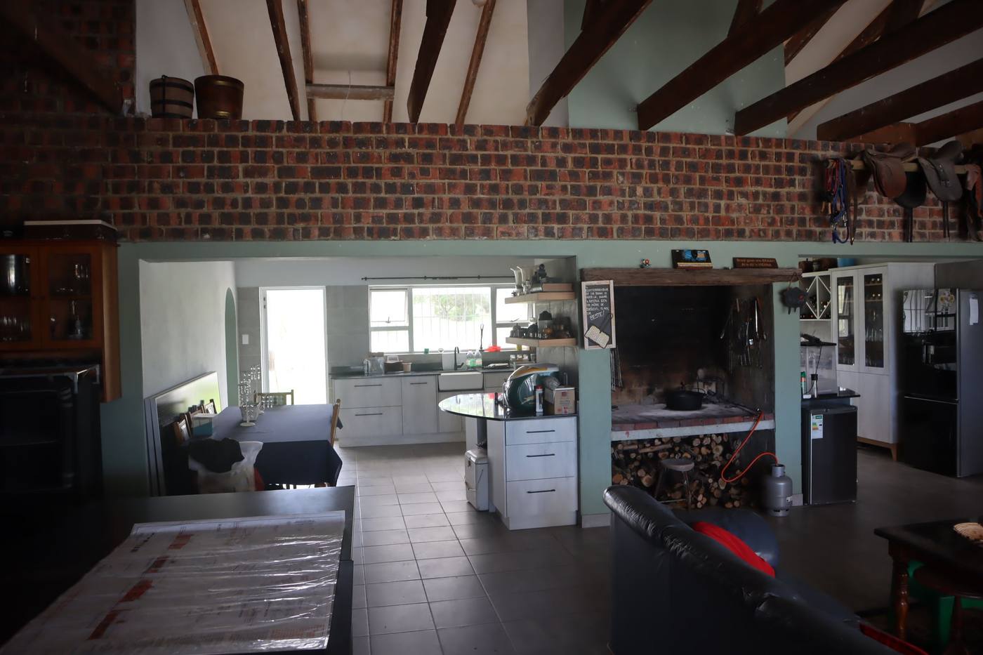 The indoor braai entertainment area, with the large fireplace and the open-plan kitchen beside it