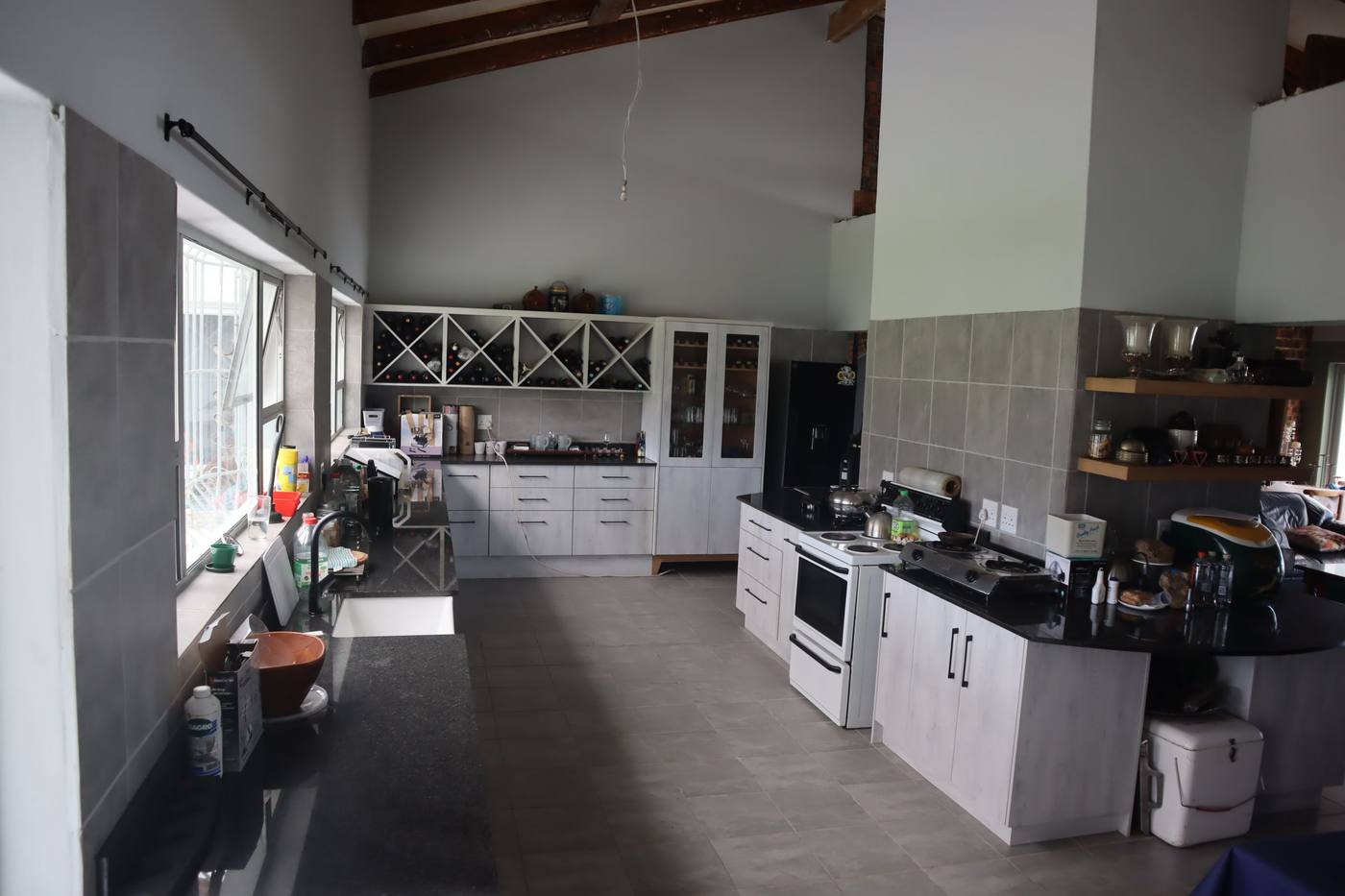 The kitchen from the other end, with the stove, wine racks and a granite-topped island
