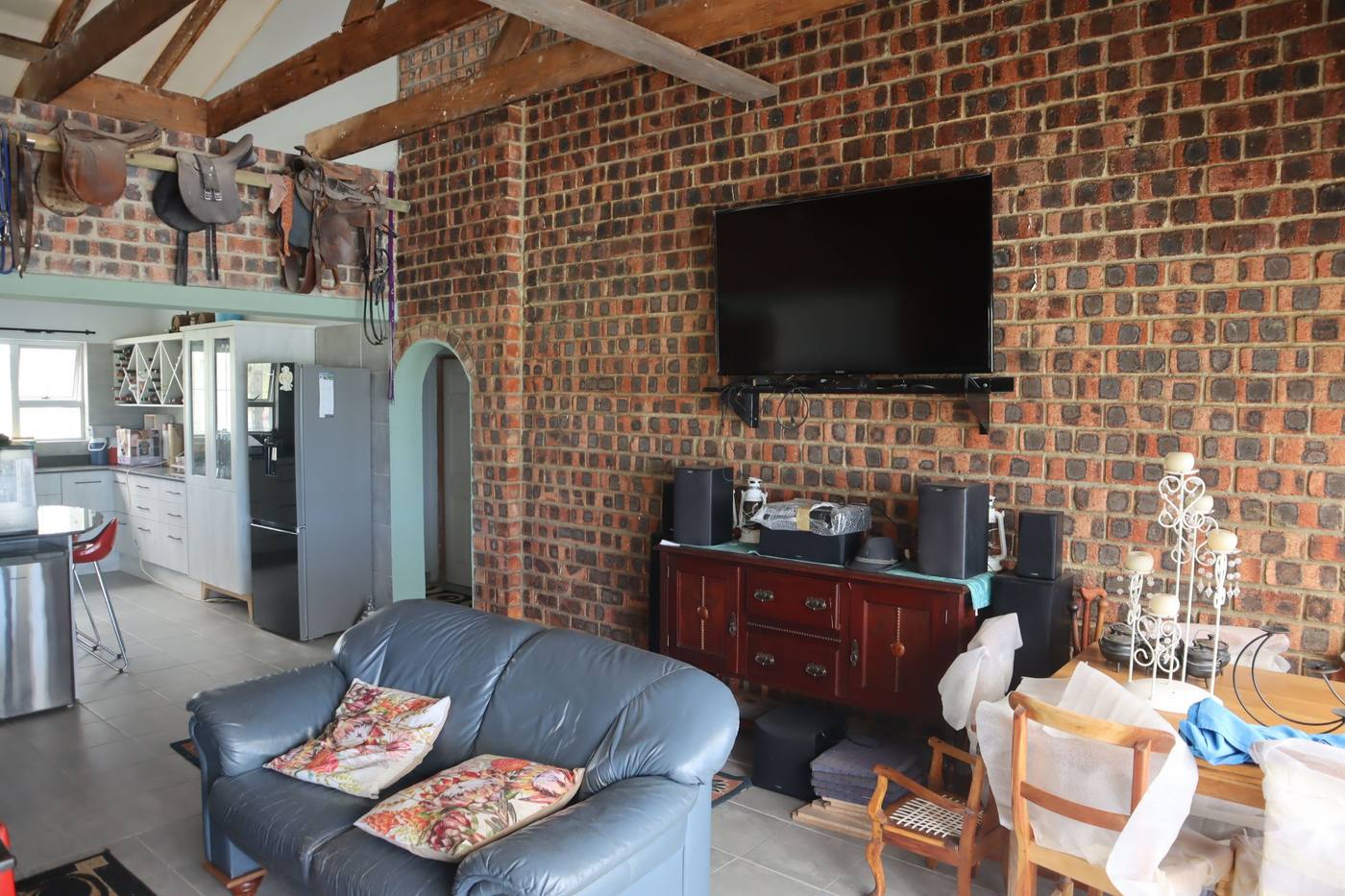 Sofas in front of the face-brick wall, with an arched doorway through to the kitchen