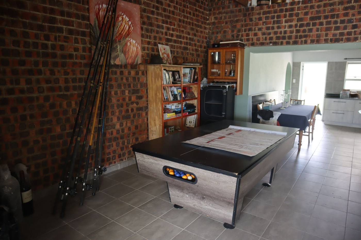 The entertainment area with a pool table, and the kitchen beyond it