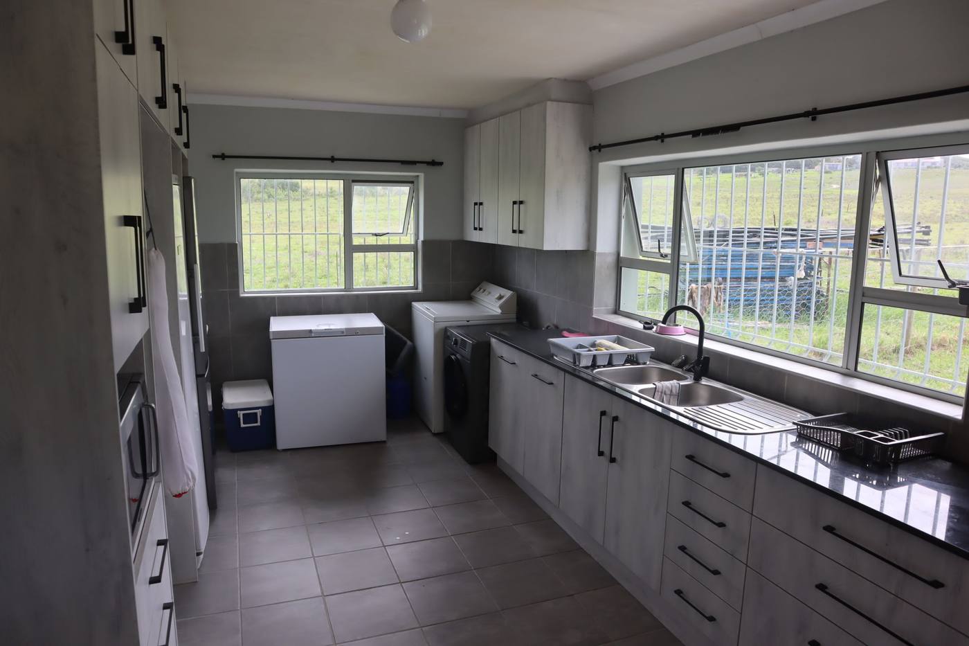 The scullery at the back, with a sink, cupboards, a pantry and space for a chest freezer