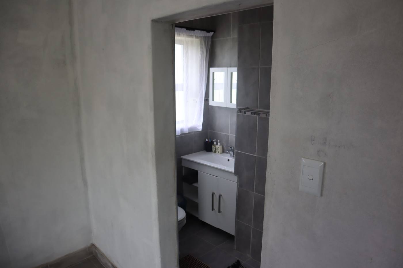 A shower room with a basin and a toilet, off one of the bedrooms