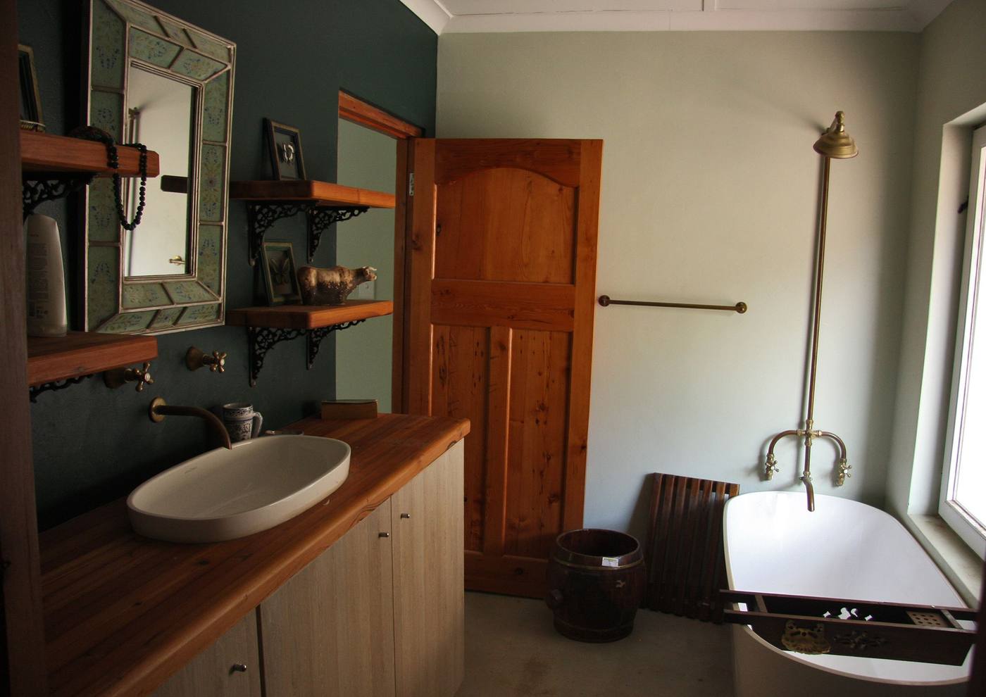 A bathroom with a timber vanity, a bowl basin and a freestanding bath