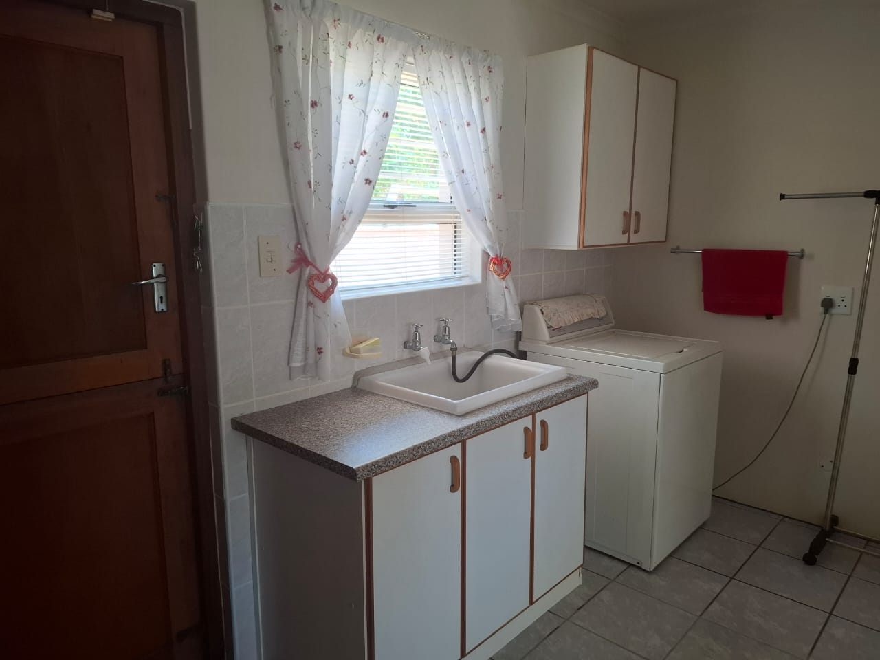The laundry, with a sink unit, a washing machine and a door to the outside