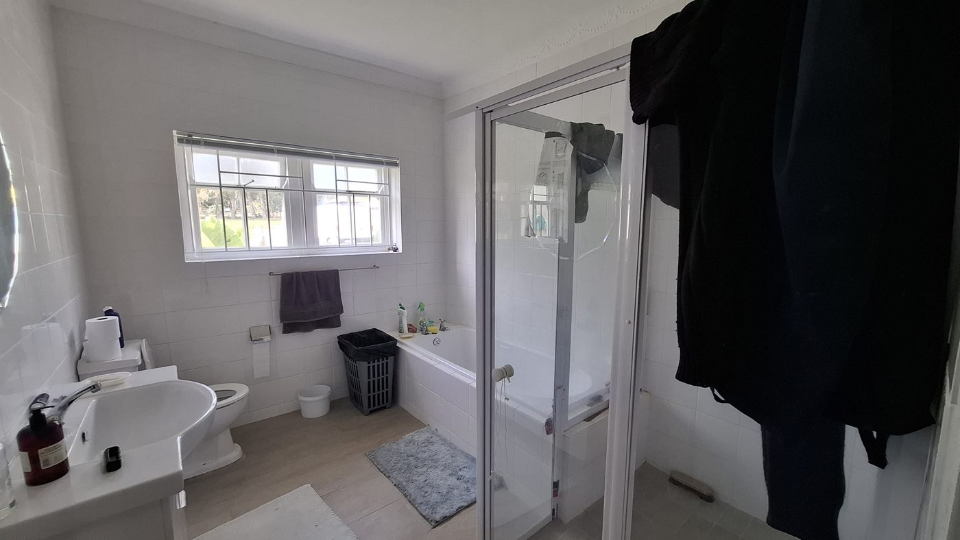 A second bathroom, with a bath, a basin and a window