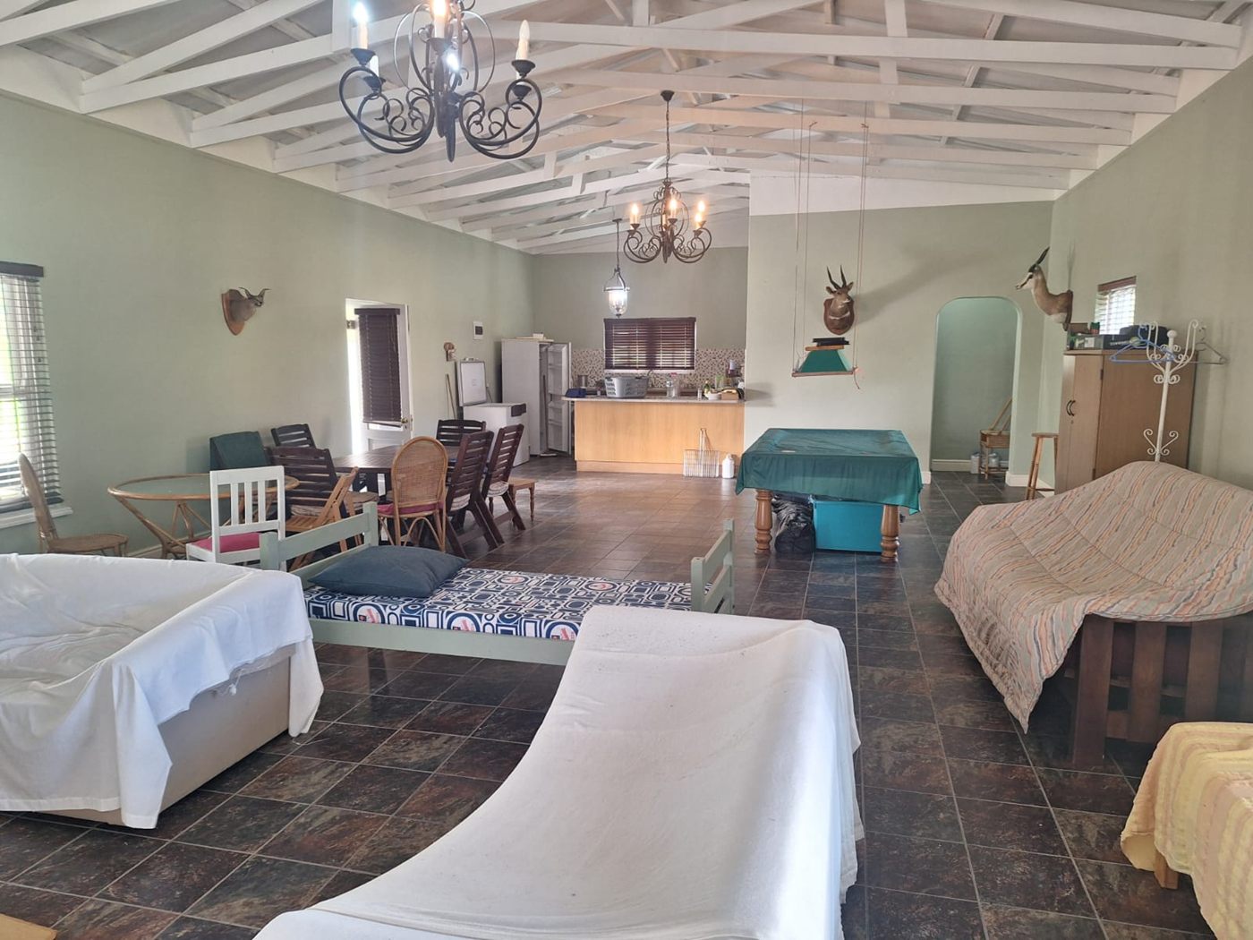 The entertainment room from the other end, with beds, a pool table and the kitchen counter
