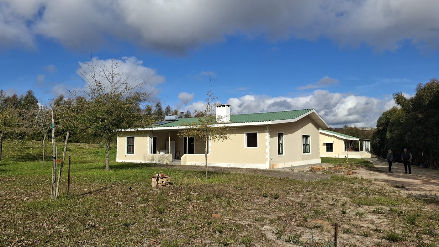 The braai-room building from the side, with young trees and the lawn in front