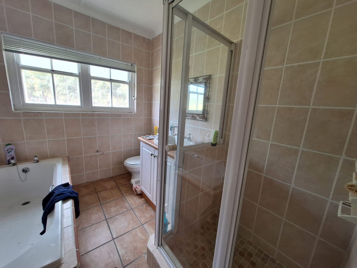 The cottage bathroom, with a bath, a glass shower and a tiled floor