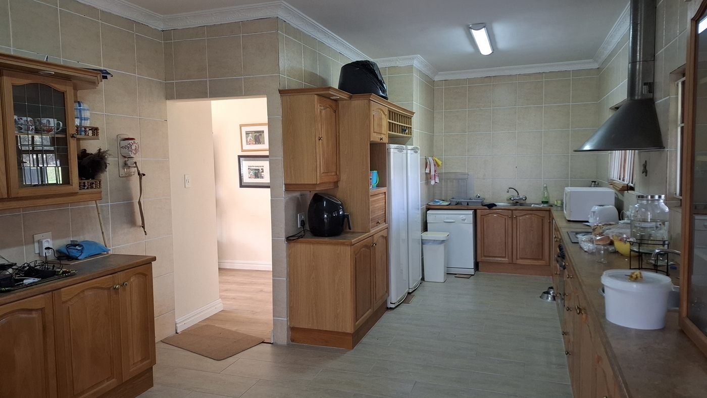 The kitchen, with wooden cupboards, a tiled wall and an extractor hood