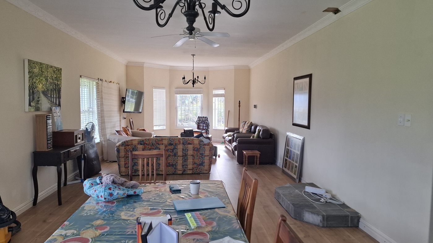 The living room: a long room with a bay window, sofas and a dining table