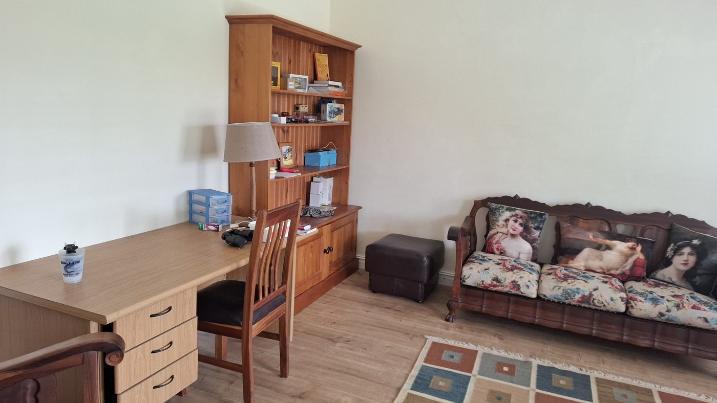 A study corner with a desk, a bookcase and a sofa