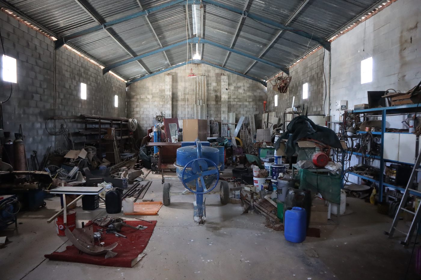 Inside the workshop shed: shelving, tools and equipment under a steel roof